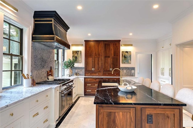 290 Blackstone Blvd, Providence, RI 02906 - kitchen with double oven range, custom exhaust hood, decorative backsplash, a center island with sink, and dark stone countertops