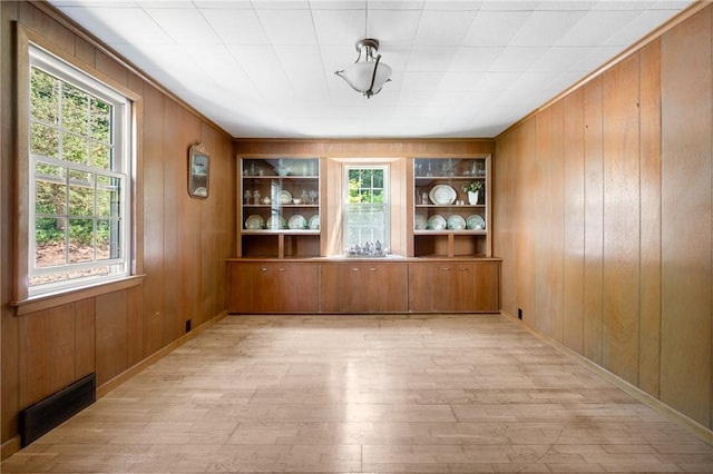355 Scott Rd, Cumberland, RI 02864 - unfurnished dining area featuring plenty of natural light, wooden walls, light wood-style flooring, and built in shelves