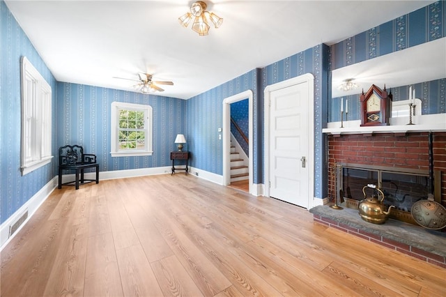 355 Scott Rd, Cumberland, RI 02864 - living area with wallpapered walls, a fireplace, wood finished floors, stairway, and a ceiling fan