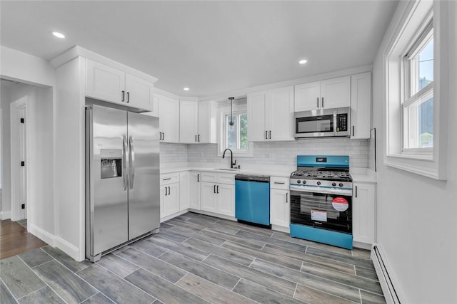 60 Hazael St, Providence, RI 02908 - kitchen featuring appliances with stainless steel finishes, white cabinetry, backsplash, light countertops, and a baseboard radiator