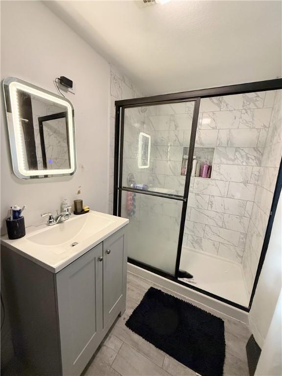 26 Westmore St, Providence, RI 02910 - bathroom featuring vanity, a shower stall, and marble look tile flooring