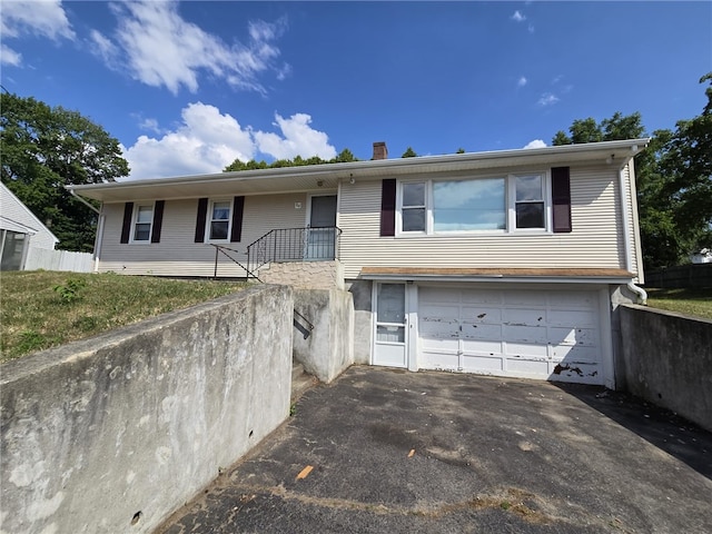 84 Bernice Ave, Woonsocket, RI 02895 - view of front of home with an attached garage, asphalt driveway, and a chimney