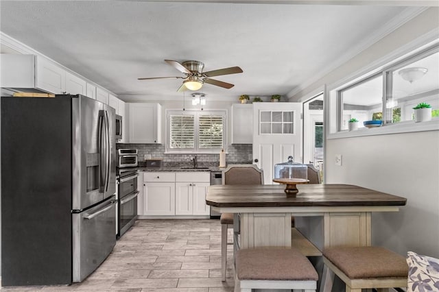 32 Spencer Rd, Smithfield, RI 02828 - kitchen with appliances with stainless steel finishes, white cabinetry, tasteful backsplash, ceiling fan, and light wood-style floors