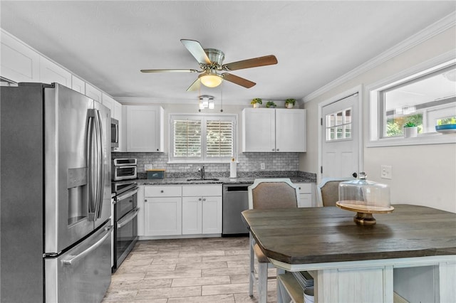 32 Spencer Rd, Smithfield, RI 02828 - kitchen featuring appliances with stainless steel finishes, healthy amount of natural light, white cabinets, and crown molding