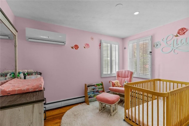 32 Spencer Rd, Smithfield, RI 02828 - bedroom with an AC wall unit, a baseboard heating unit, wood finished floors, a crib, and recessed lighting
