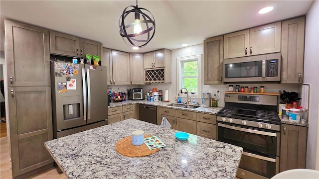 61 Terrace Ave, Pawtucket, RI 02860 - kitchen with appliances with stainless steel finishes, decorative backsplash, light stone countertops, hanging light fixtures, and recessed lighting