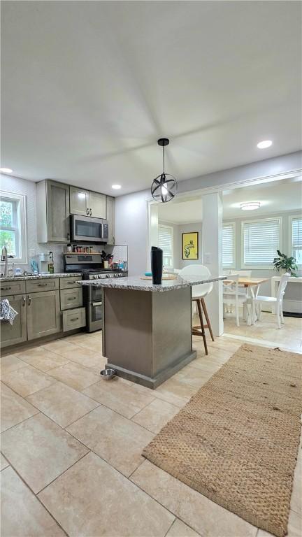 61 Terrace Ave, Pawtucket, RI 02860 - kitchen featuring appliances with stainless steel finishes, light stone countertops, gray cabinetry, recessed lighting, and a kitchen island