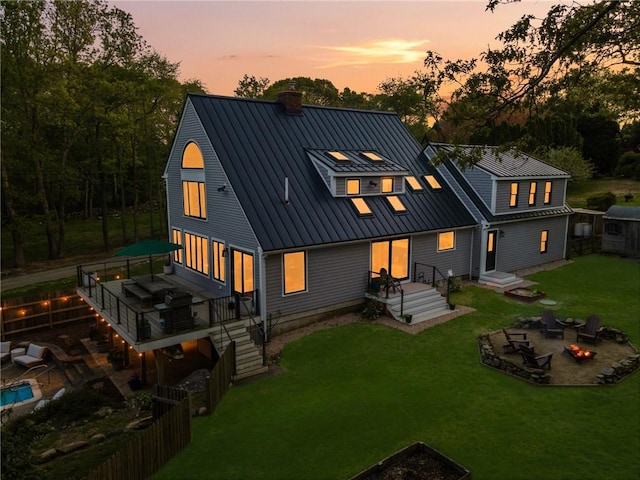 40 Charlotte Ave, North Kingstown, RI 02874 - back of property featuring an outdoor fire pit, a chimney, a standing seam roof, a metal roof, and a deck