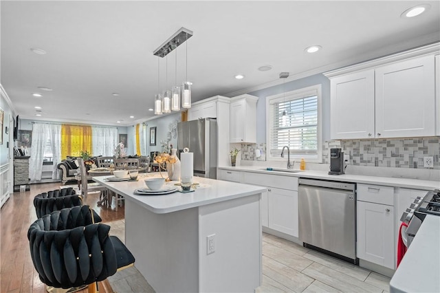 43 Amsterdam St, Providence, RI 02909 - kitchen with stainless steel appliances, open floor plan, ornamental molding, light countertops, and recessed lighting