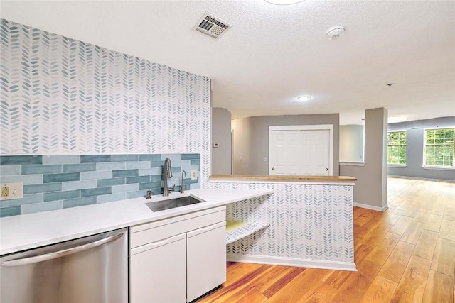 2 School St Unit 334, Lincoln, RI 02802 - kitchen with stainless steel dishwasher, light wood-style flooring, light countertops, white cabinets, and a peninsula