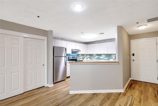 2 School St Unit 334, Lincoln, RI 02802 - kitchen featuring stainless steel appliances, a peninsula, light wood-type flooring, decorative backsplash, and a textured ceiling