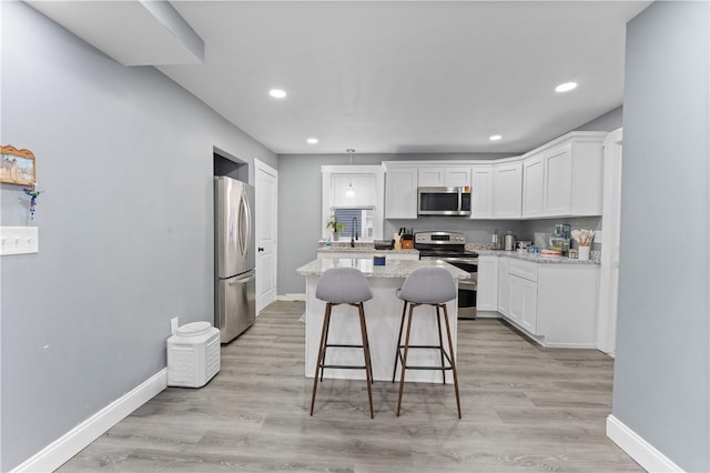 31 Stadden St, Providence, RI 02907 - kitchen with appliances with stainless steel finishes, a kitchen island, white cabinetry, a kitchen bar, and recessed lighting