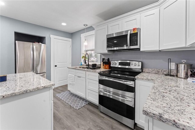 31 Stadden St, Providence, RI 02907 - kitchen featuring appliances with stainless steel finishes, recessed lighting, white cabinetry, light wood-style floors, and light stone counters