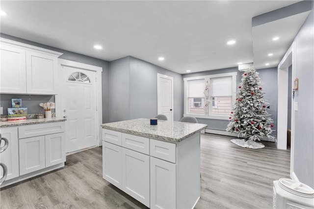 31 Stadden St, Providence, RI 02907 - kitchen with light wood-style flooring, white cabinets, recessed lighting, a center island, and light stone counters