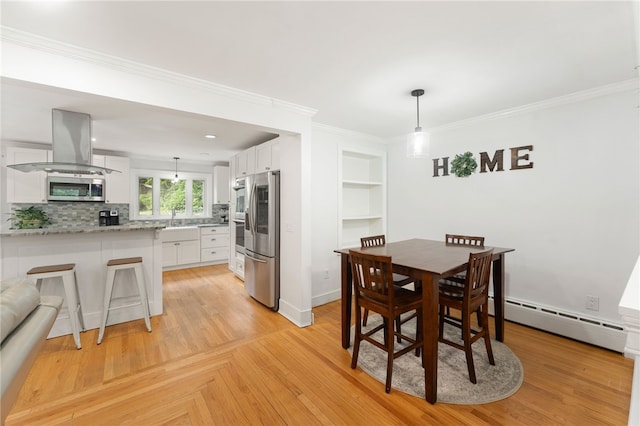15 Bestwick Trl, Coventry, RI 02816 - dining room with a baseboard heating unit, ornamental molding, built in shelves, and light wood-style floors
