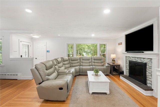 15 Bestwick Trl, Coventry, RI 02816 - living room with a baseboard heating unit, ornamental molding, light wood-style floors, recessed lighting, and a stone fireplace