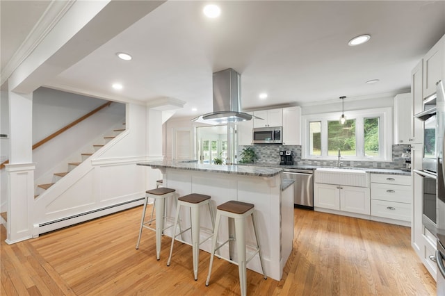 15 Bestwick Trl, Coventry, RI 02816 - kitchen with stainless steel appliances, a baseboard radiator, a kitchen bar, crown molding, and tasteful backsplash