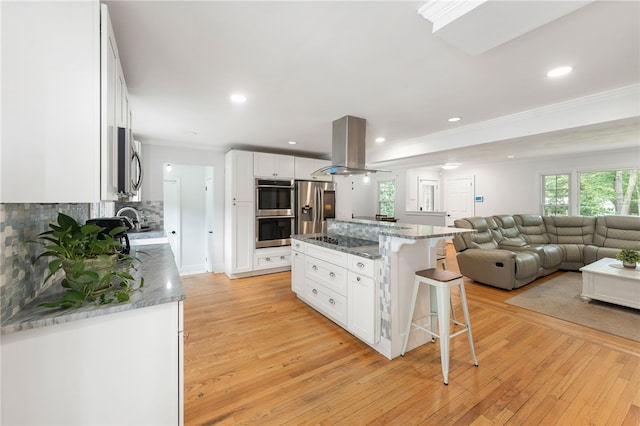 15 Bestwick Trl, Coventry, RI 02816 - kitchen with island exhaust hood, stainless steel appliances, a breakfast bar, white cabinetry, and crown molding