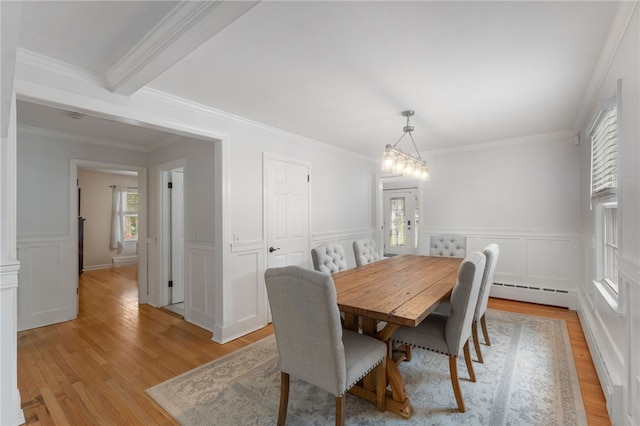 15 Bestwick Trl, Coventry, RI 02816 - dining space featuring a baseboard radiator, light wood-style floors, a decorative wall, crown molding, and wainscoting