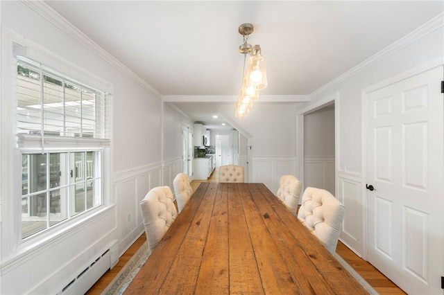 15 Bestwick Trl, Coventry, RI 02816 - dining room with a baseboard heating unit, a decorative wall, ornamental molding, wainscoting, and wood finished floors