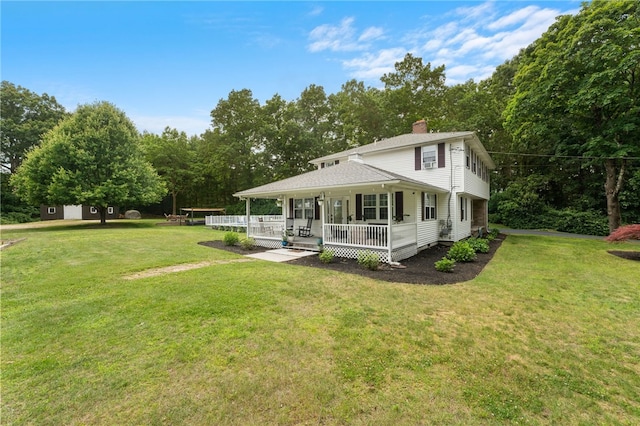 15 Bestwick Trl, Coventry, RI 02816 - back of house featuring a chimney, a yard, and covered porch