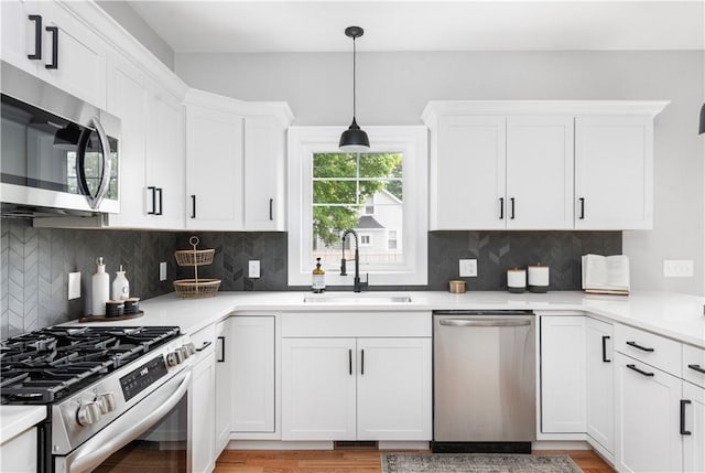 119 Myrtle Ave, Cranston, RI 02910 - kitchen with appliances with stainless steel finishes, white cabinets, backsplash, and light countertops