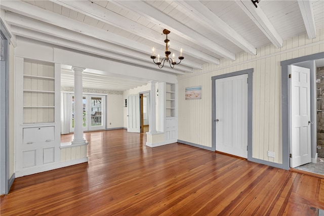 1 Barney Ave, South Kingstown, RI 02879 - unfurnished living room with ornate columns, wood-type flooring, beamed ceiling, and a chandelier