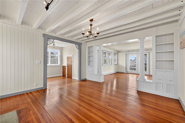 1 Barney Ave, South Kingstown, RI 02879 - unfurnished living room with ornate columns, a baseboard radiator, hardwood / wood-style floors, beam ceiling, and a chandelier