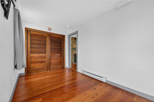 1 Barney Ave, South Kingstown, RI 02879 - unfurnished bedroom with a baseboard heating unit and wood finished floors