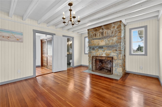 1 Barney Ave, South Kingstown, RI 02879 - unfurnished living room with hardwood / wood-style flooring, a chandelier, plenty of natural light, a stone fireplace, and beam ceiling