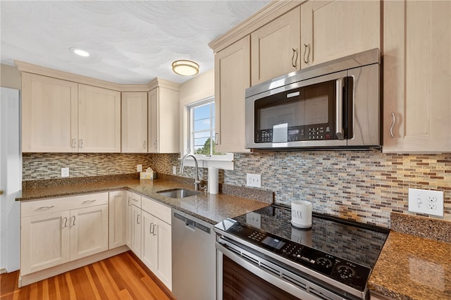 1 Barney Ave, South Kingstown, RI 02879 - kitchen with stainless steel appliances, light wood finished floors, backsplash, and dark stone counters