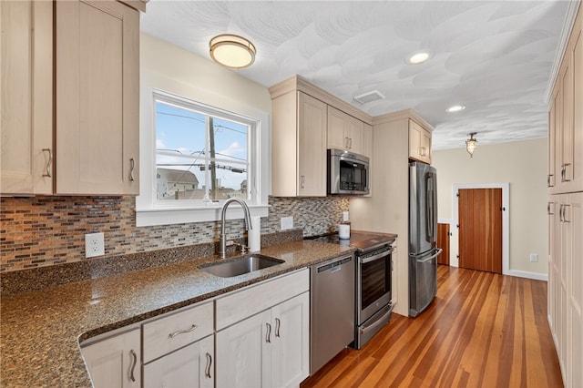 1 Barney Ave, South Kingstown, RI 02879 - kitchen with appliances with stainless steel finishes, light wood-style floors, decorative backsplash, dark stone countertops, and recessed lighting