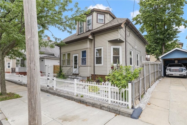 155 Early St, Providence, RI 02907 - view of front of house featuring entry steps, a carport, roof with shingles, and a fenced front yard