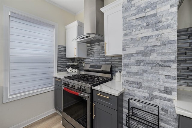 155 Early St, Providence, RI 02907 - kitchen with wall chimney exhaust hood, stainless steel gas range oven, backsplash, gray cabinets, and light wood finished floors