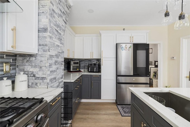 155 Early St, Providence, RI 02907 - kitchen featuring fridge, white cabinetry, decorative backsplash, light stone countertops, and crown molding