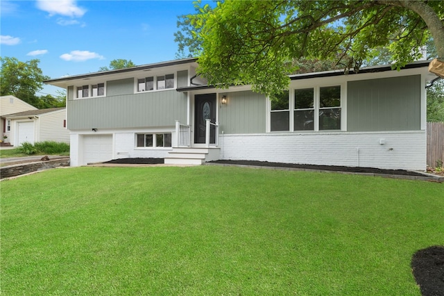 19 Cushing Rd, Warwick, RI 02888 - split level home featuring brick siding, a front lawn, and a garage