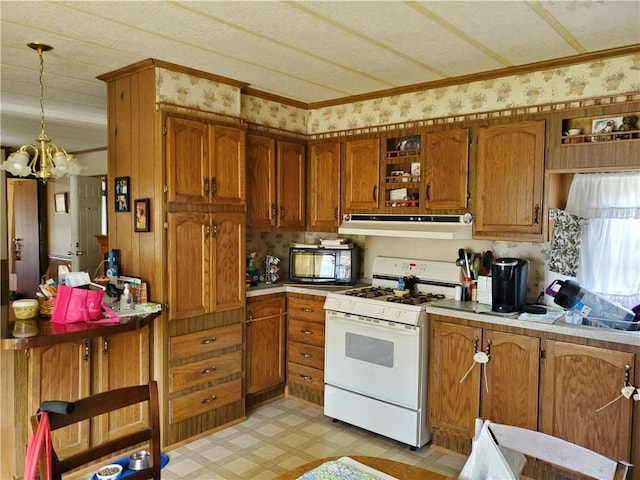 26 Lane E, Coventry, RI 02816 - kitchen with white gas stove, under cabinet range hood, black microwave, brown cabinets, and light flooring