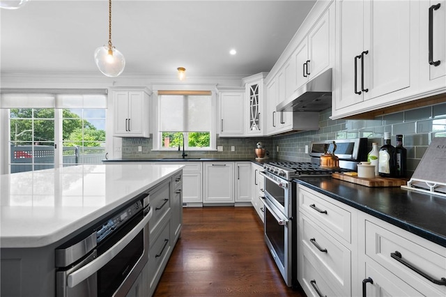 96 Evergreen St, Cumberland, RI 02864 - kitchen with range with two ovens, under cabinet range hood, backsplash, white cabinetry, and recessed lighting