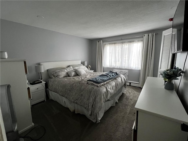 494 Putnam Pike Unit A12, Smithfield, RI 02828 - bedroom with dark carpet, a baseboard radiator, and a textured ceiling