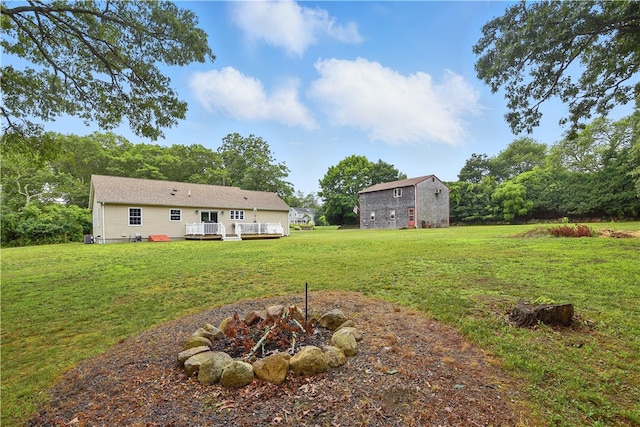 107 Pottersville Rd, Little Compton, RI 02837 - view of green lawn with a deck, an outbuilding, and an outdoor fire pit