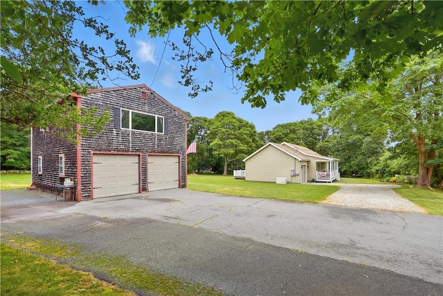 107 Pottersville Rd, Little Compton, RI 02837 - view of home's exterior featuring an attached garage, driveway, and a lawn