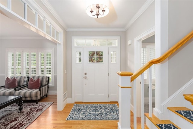 64 Knight View Dr, West Greenwich, RI 02817 - entrance foyer featuring light wood-style floors, stairway, crown molding, and a chandelier