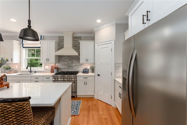 64 Knight View Dr, West Greenwich, RI 02817 - kitchen featuring appliances with stainless steel finishes, wall chimney range hood, crown molding, light wood-type flooring, and tasteful backsplash