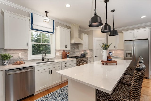 64 Knight View Dr, West Greenwich, RI 02817 - kitchen featuring appliances with stainless steel finishes, wall chimney range hood, a breakfast bar area, light wood-style floors, and ornamental molding