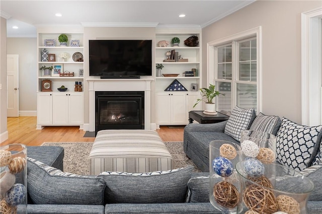 64 Knight View Dr, West Greenwich, RI 02817 - living room featuring light wood-type flooring, a fireplace with flush hearth, crown molding, recessed lighting, and built in shelves