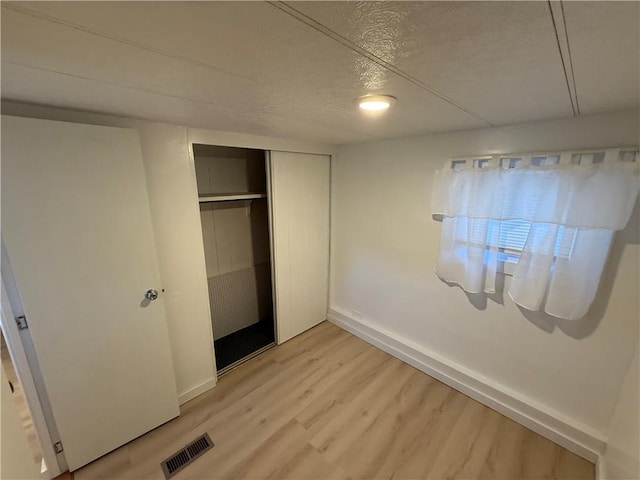 5 Ln 7, Coventry, RI 02816 - unfurnished bedroom featuring light wood-style floors, a closet, and a textured ceiling