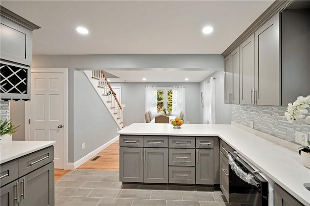 12 Leddy Rd, Cumberland, RI 02864 - kitchen with gray cabinets, dishwasher, a peninsula, light countertops, and decorative backsplash