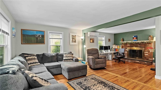 74 Algonquin Rd, East Providence, RI 02916 - living area featuring light wood-style floors, a wall mounted air conditioner, and a fireplace