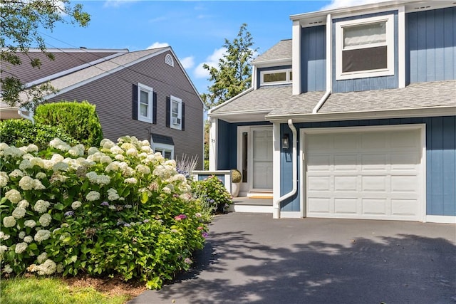 33 Arbor Dr Unit 27, Providence, RI 02908 - view of front of house featuring a garage, roof with shingles, driveway, and board and batten siding