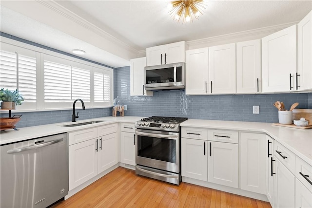 33 Arbor Dr Unit 27, Providence, RI 02908 - kitchen with stainless steel appliances, backsplash, light countertops, white cabinets, and crown molding
